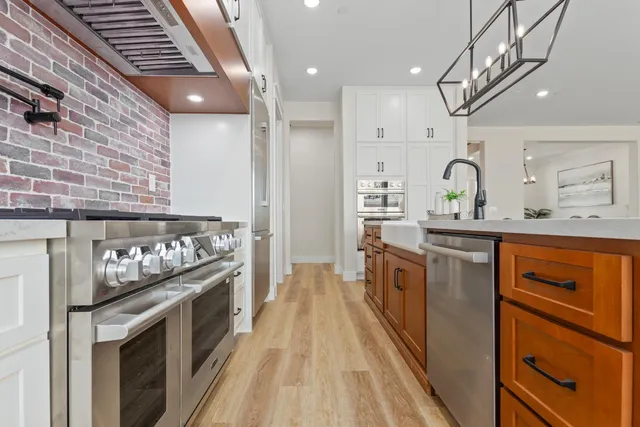 a kitchen with stainless steel appliances granite countertop a stove and a sink