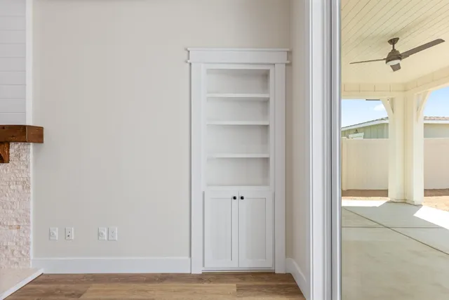 a view of a hallway with wooden floor and a bathroom