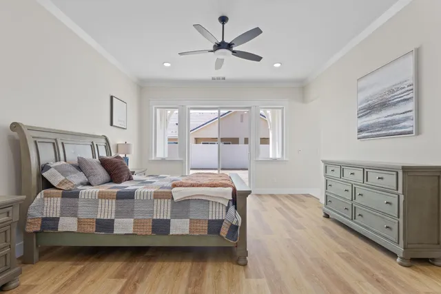 a bedroom with a bed a dresser and next to a window