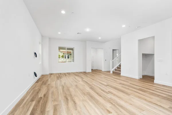 a view of empty room with wooden floor