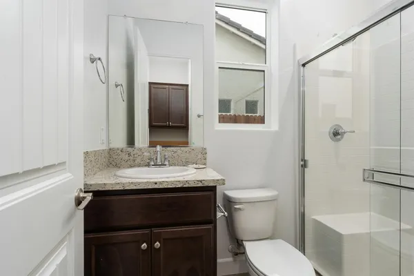 a bathroom with a granite countertop sink toilet and shower