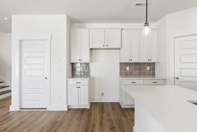 a kitchen with cabinets appliances and a wooden floor
