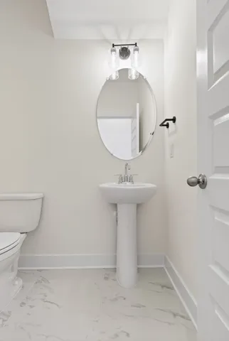 a bathroom with a sink toilet and a mirror