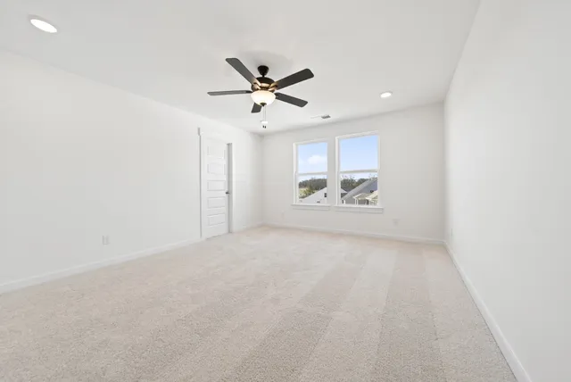 en empty room with window and ceiling fan