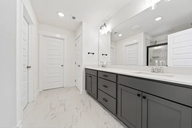 a spacious bathroom with double sink and mirror