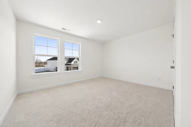 an empty room with a white wall and a shower