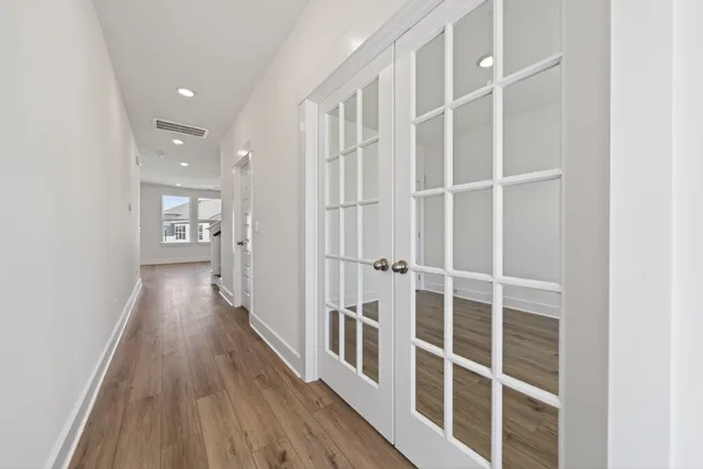a view of a hallway with wooden floor and staircase