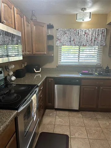 a kitchen with granite countertop a stove sink and cabinets