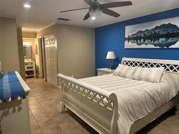 a bedroom with a bed and a painting on the wall