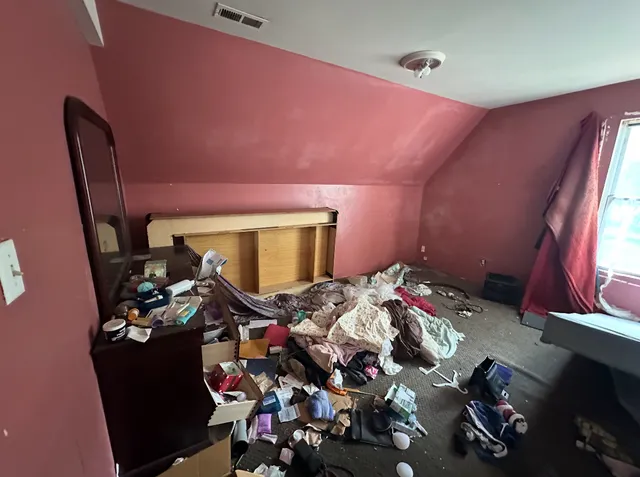 a bedroom with bed and a mirror