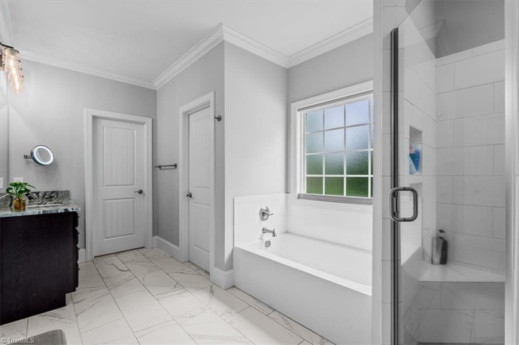 8868 Belews Ridge Road Stokesdale, NC 27357 - Photo 22 of 39 Closet envy is real. ?? The expansive primary walk-in closet feels like a private boutique, complete with custom shelving and built-in drawers.
