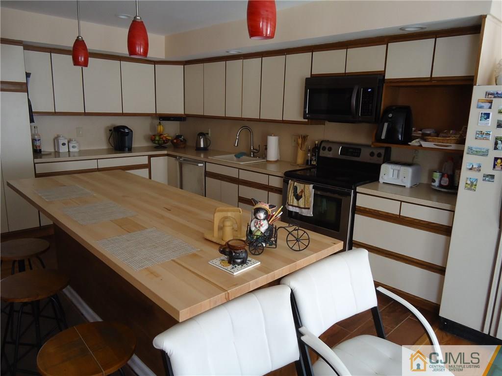 141 Long Hill Road Colonia, NJ 07067 - Photo 3 of 22 a kitchen with a dining table and chairs
