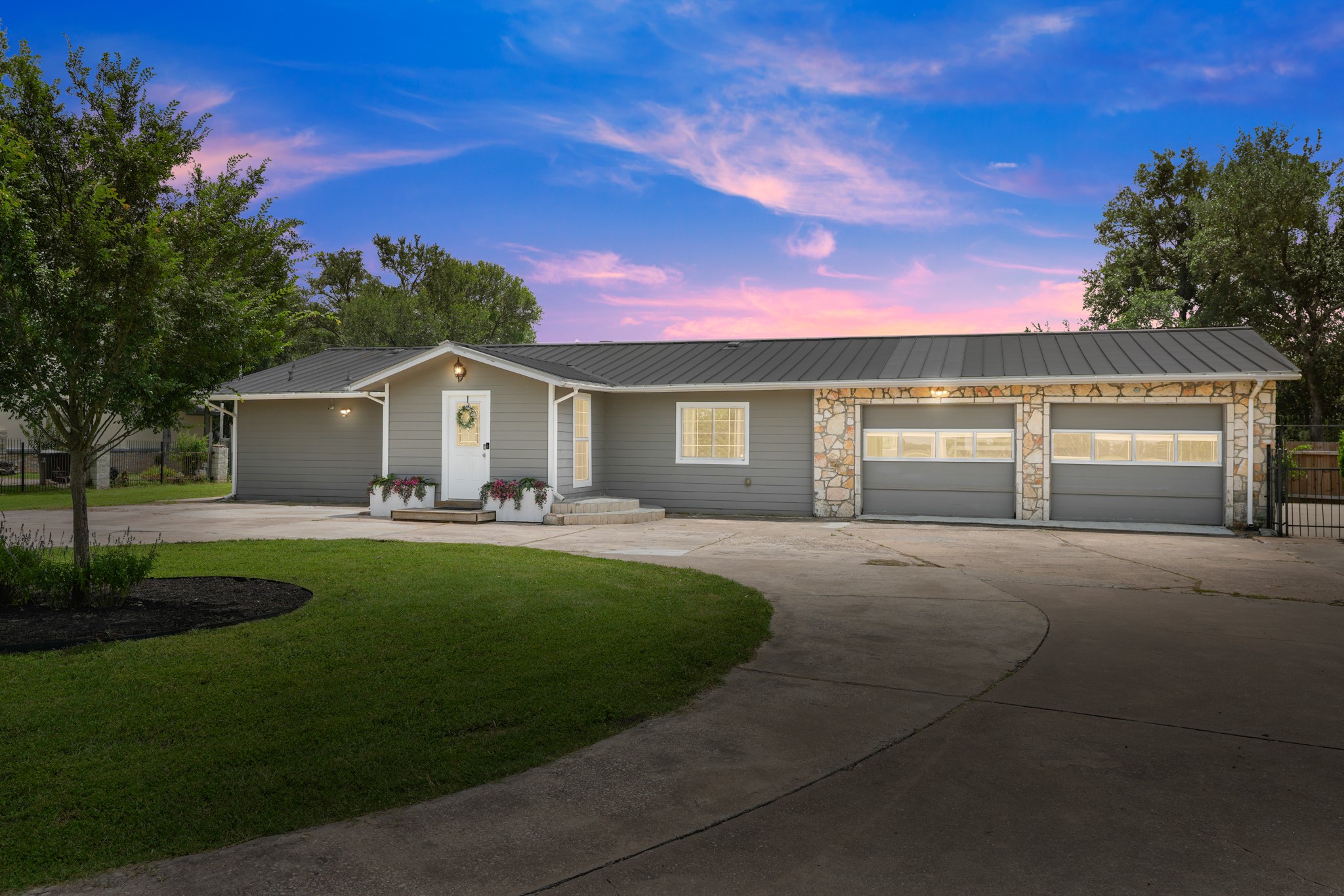 9725 Bock Road Buda, TX 78610 - Photo 1 of 32 An inviting exterior with a manicured lawn and attached garage.