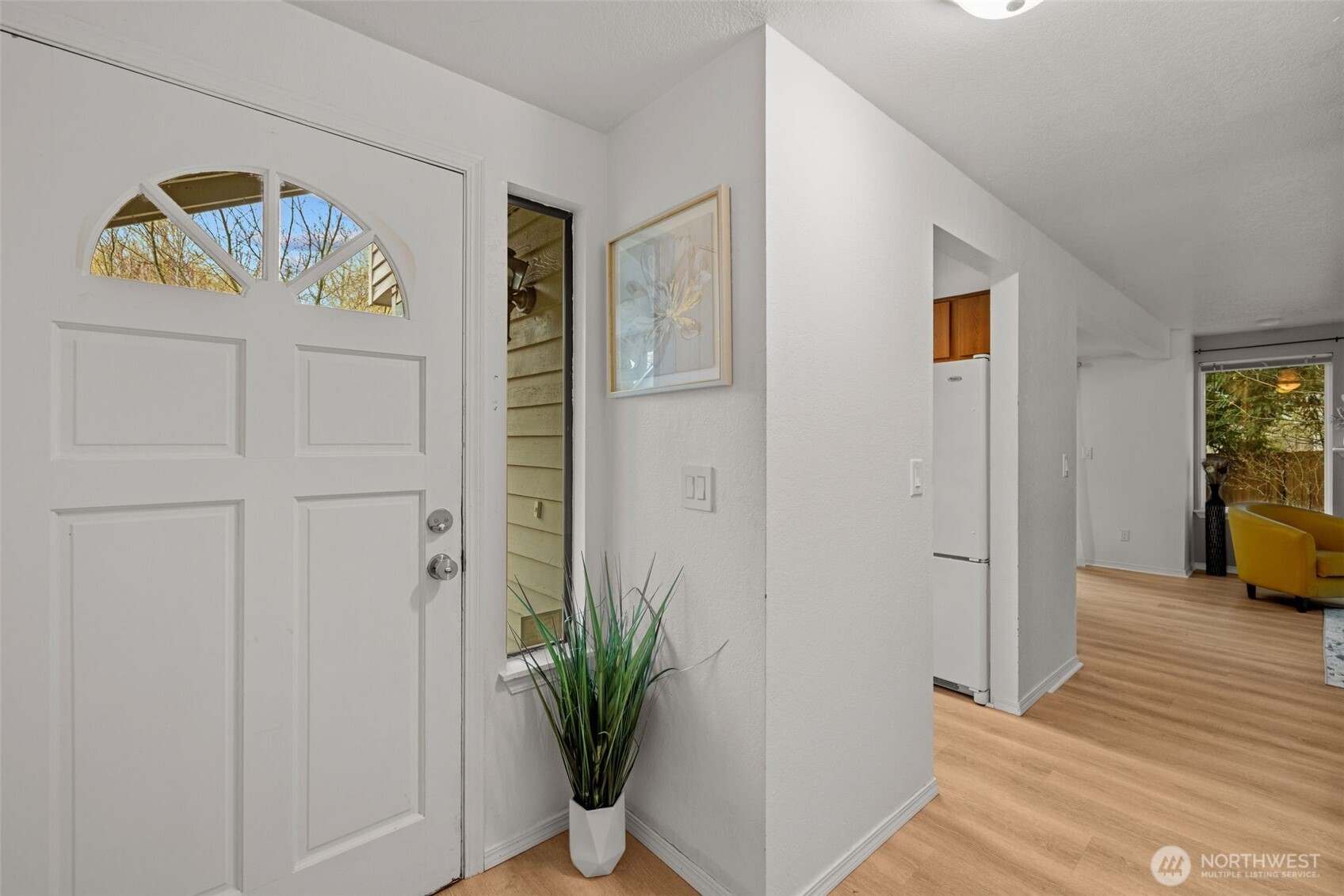 18429 20th Drive Southeast Bothell, WA 98012 - Photo 3 of 26 a view of a hallway to a livingroom with wooden floor and a potted plant