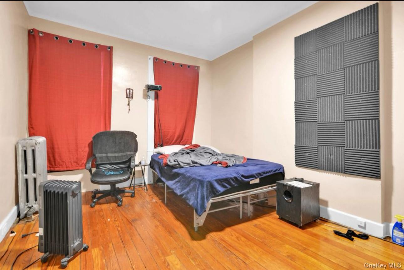 88-22 85th Street Queens, NY 11421 - Photo 18 of 33 Bedroom with radiator heating unit and wood-type flooring