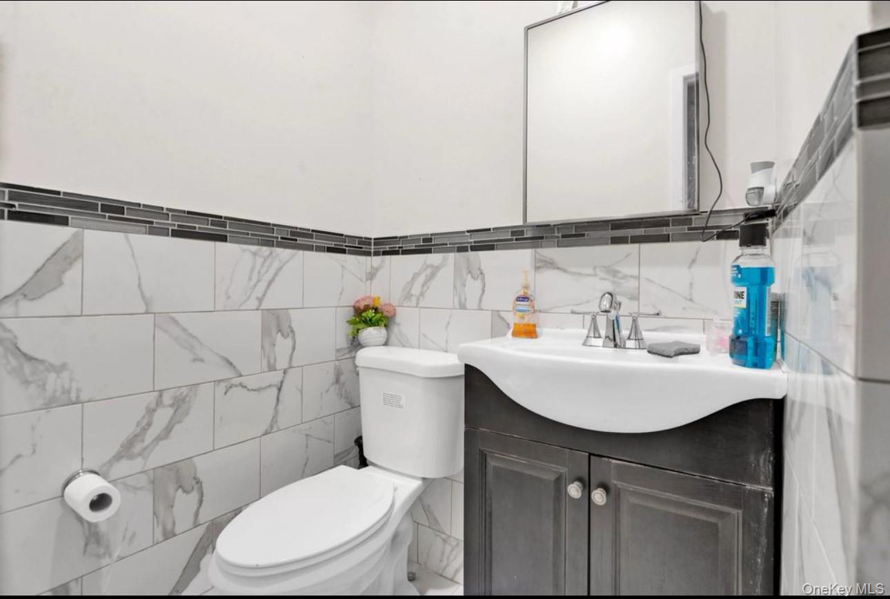 88-22 85th Street Queens, NY 11421 - Photo 20 of 33 Bathroom with vanity and tile walls