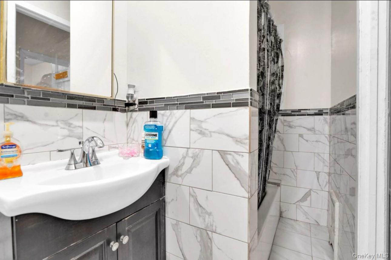 88-22 85th Street Queens, NY 11421 - Photo 21 of 33 Bathroom with vanity and shower / bathtub combination with curtain