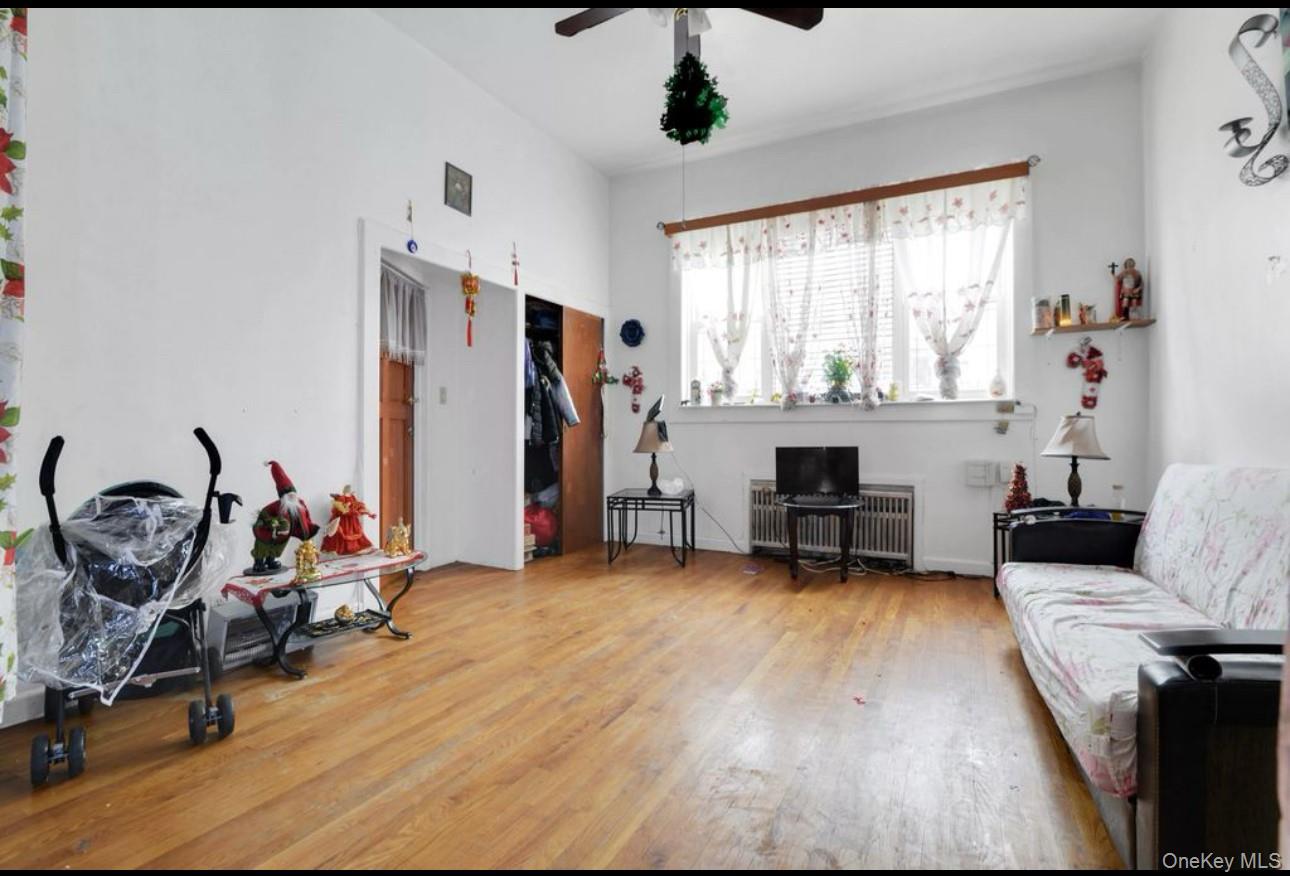 88-22 85th Street Queens, NY 11421 - Photo 4 of 33 Living area with wood finished floors and a ceiling fan