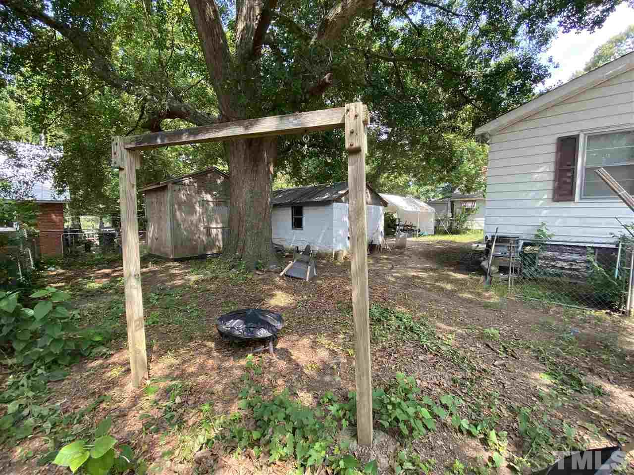 1005 Fuller Street Raleigh, NC 27603 - Photo 6 of 13 a backyard of a house with barbeque oven fire pit table and chairs