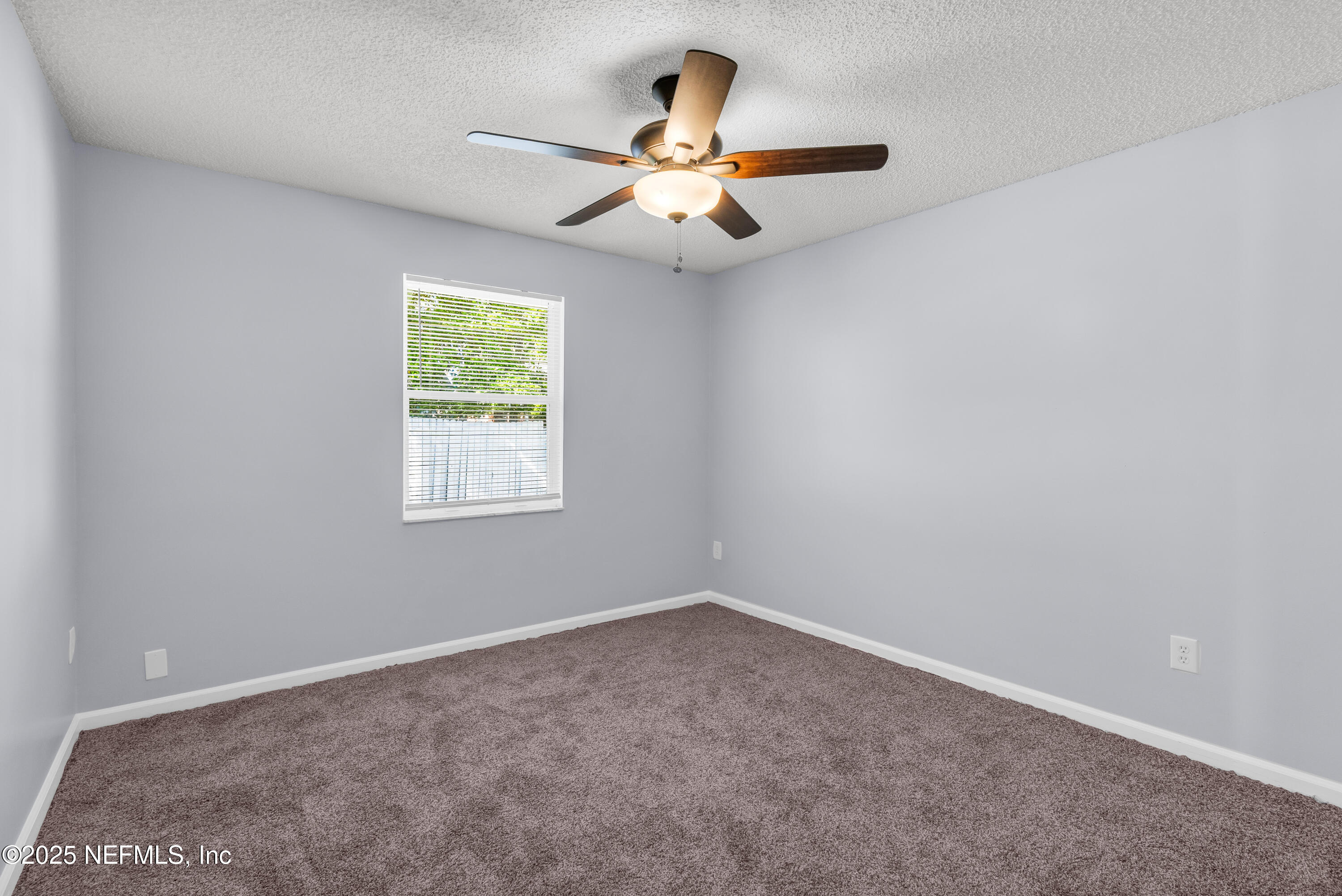 3950 Star Tree Road Jacksonville, FL 32210 - Photo 31 of 33 an empty room with window and chandelier fan