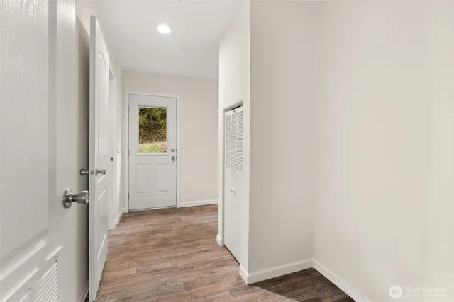 a view of a hallway with wooden floor