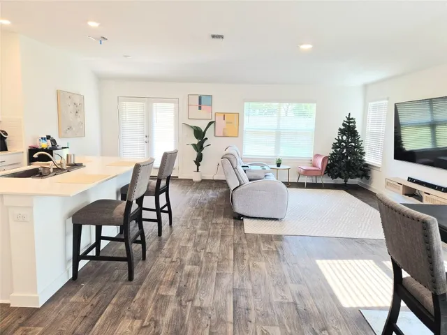 a living room with furniture a flat screen tv and a large window