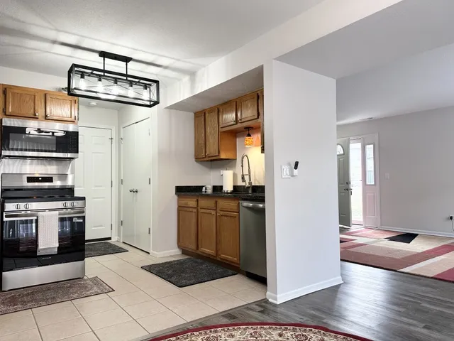 a kitchen with stainless steel appliances granite countertop a stove a sink and a refrigerator
