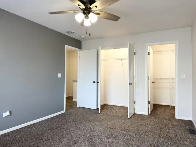 a view of a big room with chandelier fan and closet area
