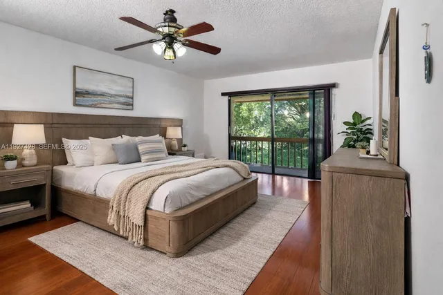 a bedroom with a large bed and a chandelier fan