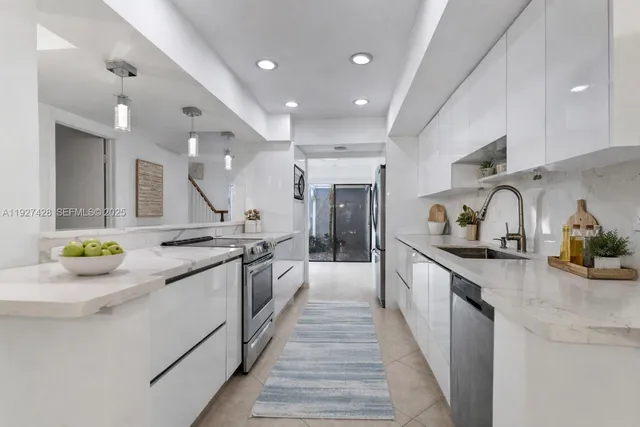 a large kitchen with stainless steel appliances and a view of living room