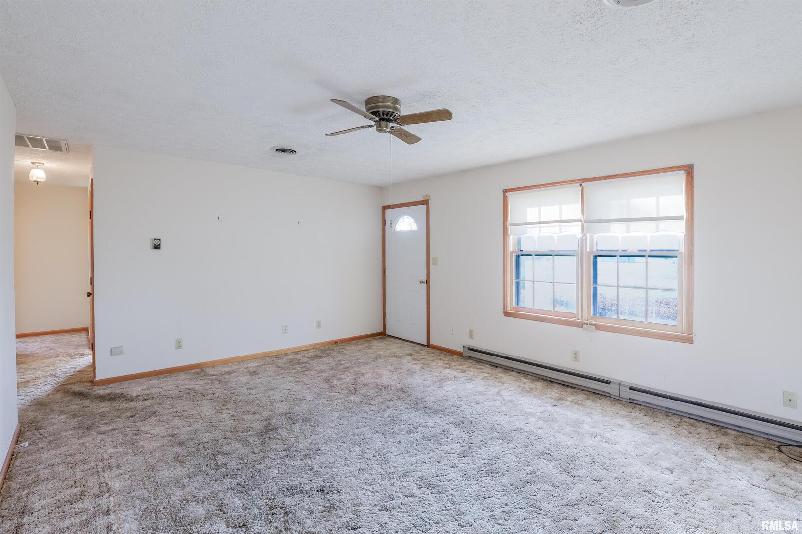 15546 Pittsburg Road Pittsburg, IL 62974 - Photo 7 of 48 an empty room with windows and ceiling fan view