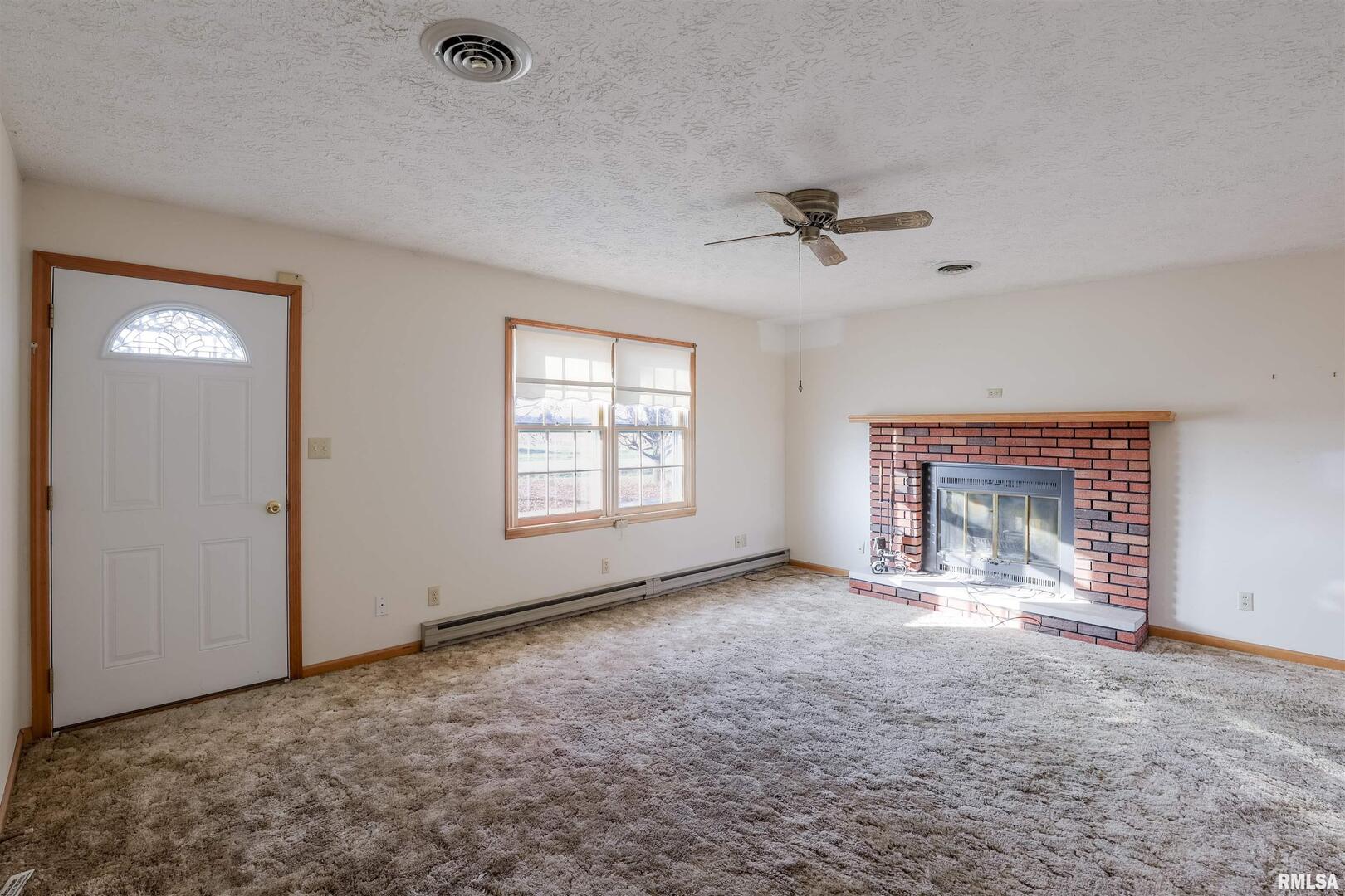 15546 Pittsburg Road Pittsburg, IL 62974 - Photo 8 of 48 a view of an empty room with a fireplace and a window