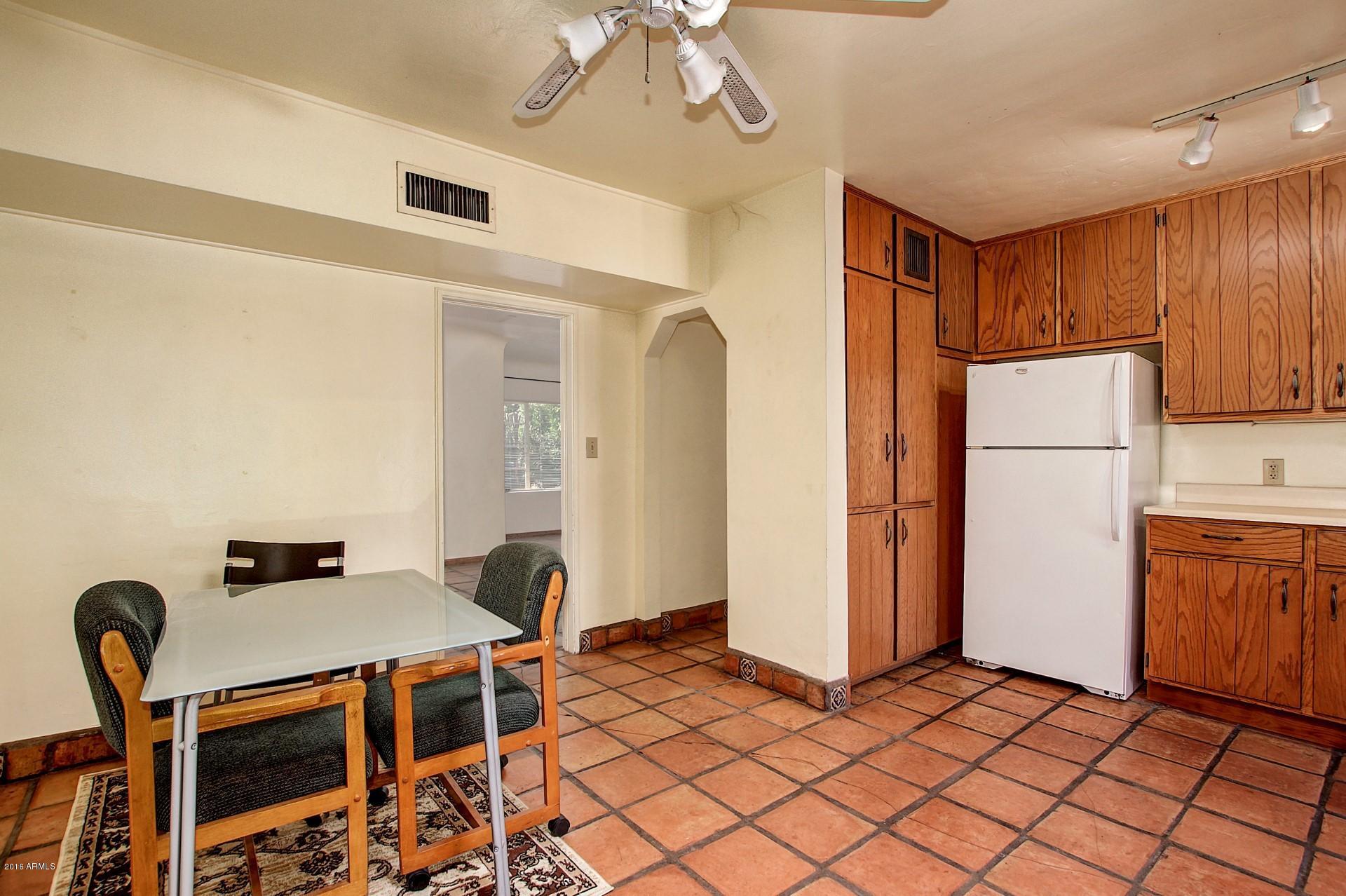 330 East 14th Street Tempe, AZ 85281 - Photo 8 of 26 a dining room with furniture a refrigerator and a stove top oven