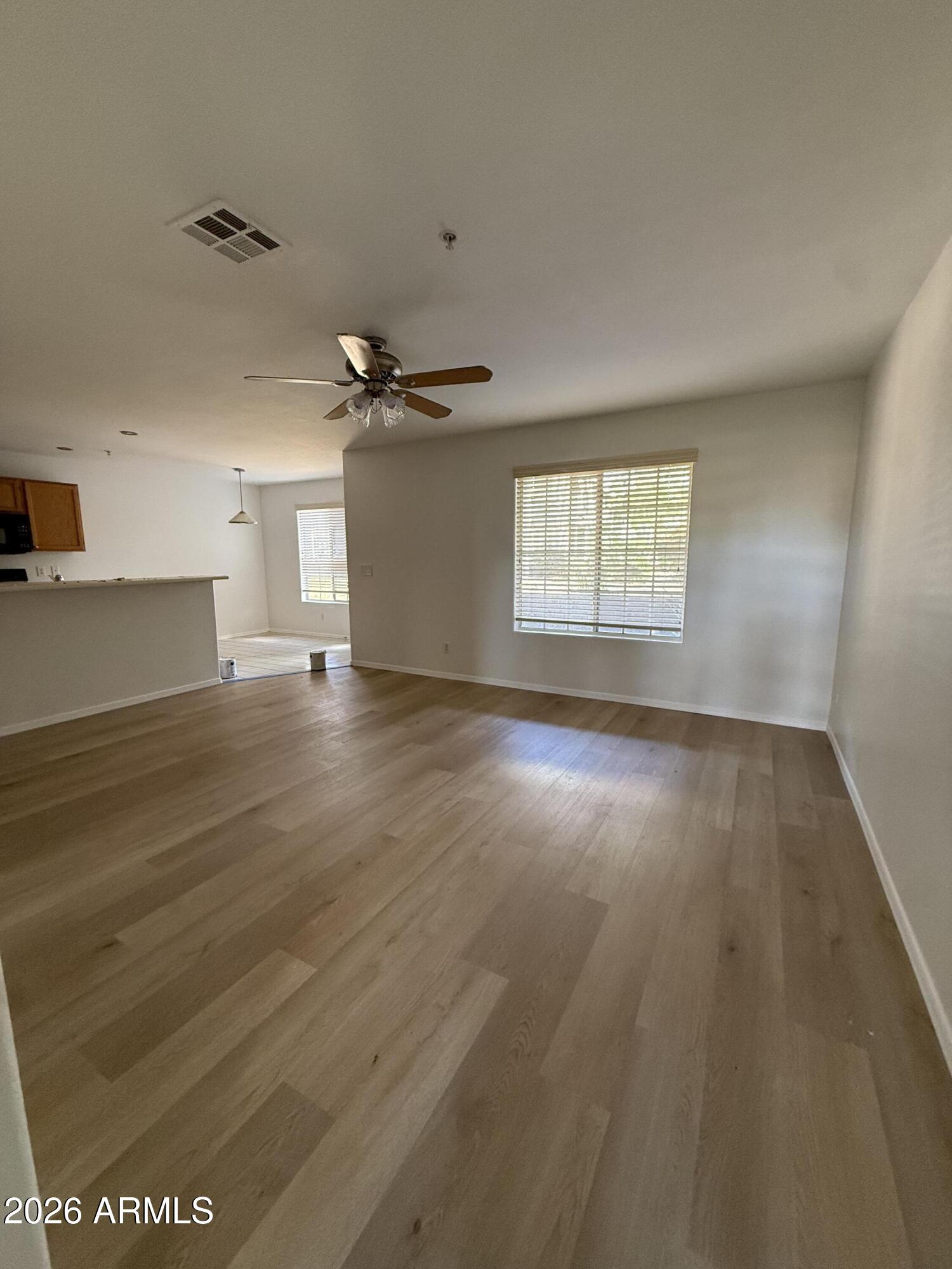 255 South Kyrene Road, Unit 140 Chandler, AZ 85226 - Photo 2 of 13 an empty room with wooden floor and windows