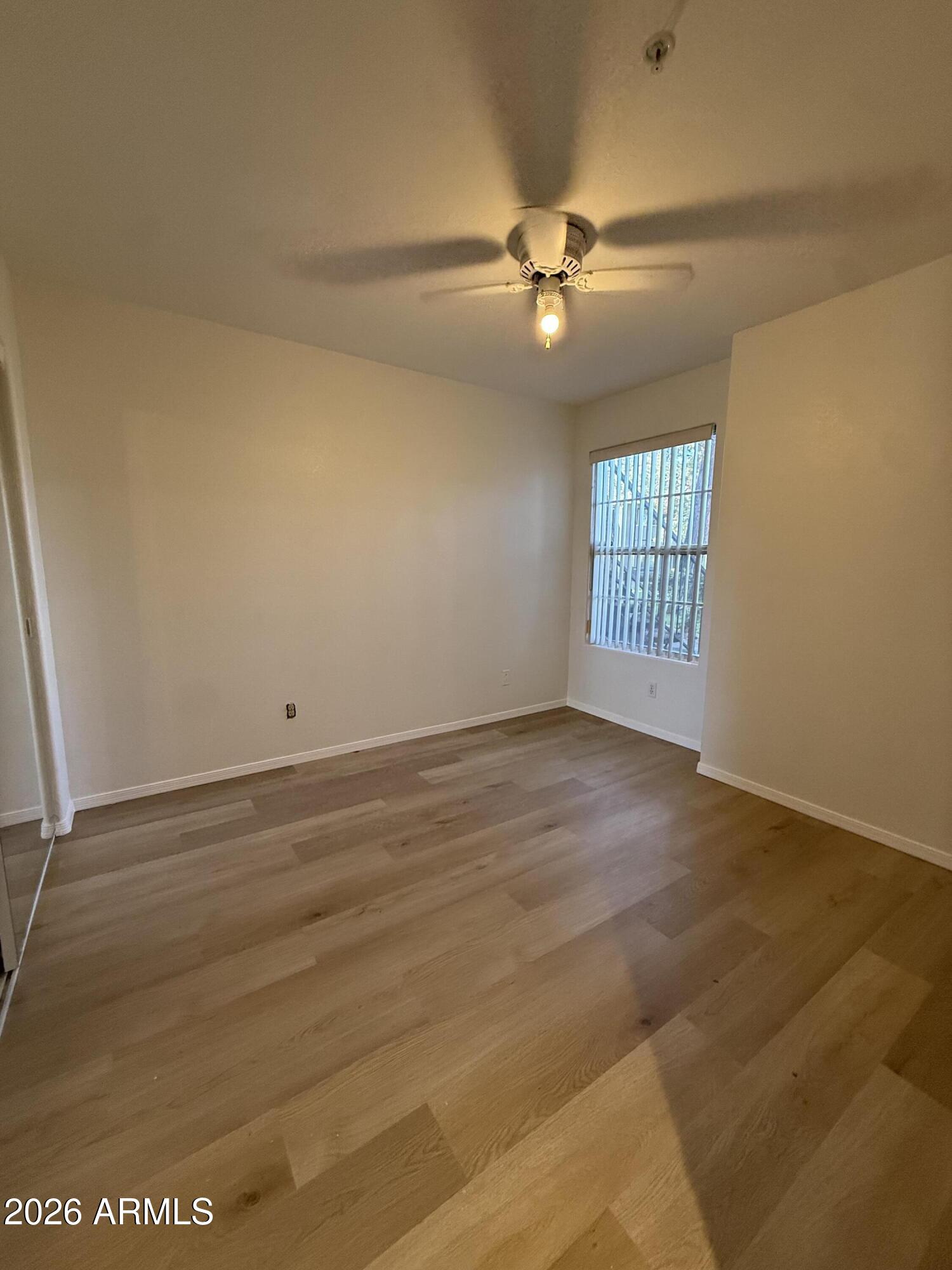 255 South Kyrene Road, Unit 140 Chandler, AZ 85226 - Photo 6 of 13 an empty room with wooden floor fan and windows