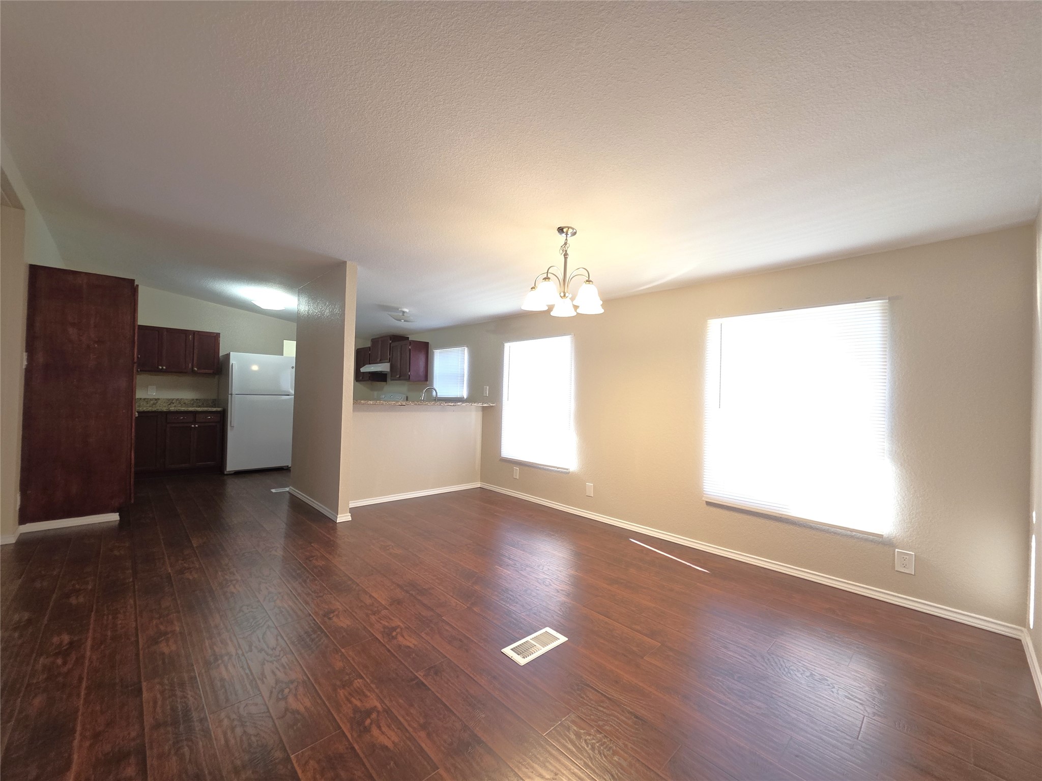 9 Ridgeway Drive Conroe, TX 77303 - Photo 5 of 15 an empty room with wooden floor kitchen view and a window