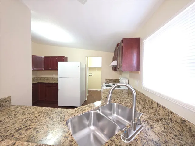 a kitchen with a refrigerator and a sink