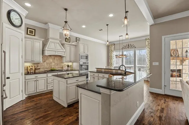 a kitchen with stainless steel appliances granite countertop a sink a stove and a wooden floors