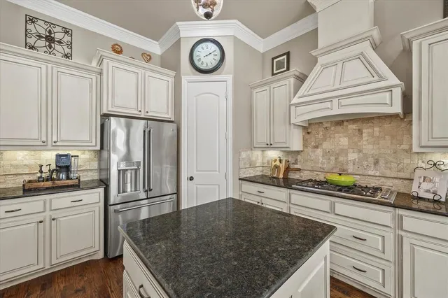 a kitchen with stainless steel appliances granite countertop a sink a stove and cabinets