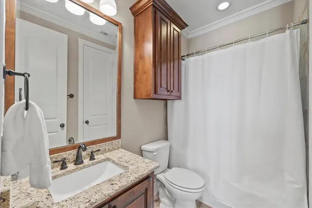a bathroom with a granite countertop sink toilet and shower