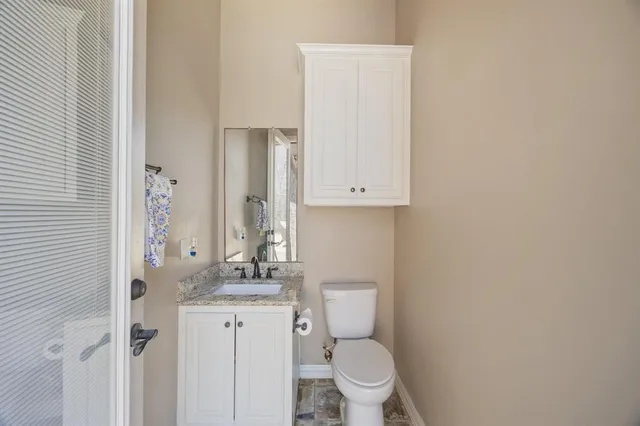 a bathroom with a granite countertop toilet and sink