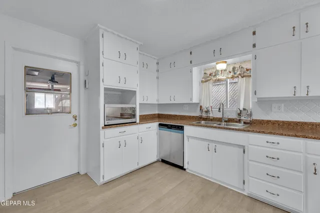a kitchen with granite countertop white cabinets and white appliances