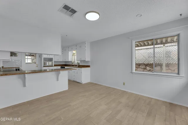 a view of kitchen with kitchen island a sink stainless steel appliances and cabinets