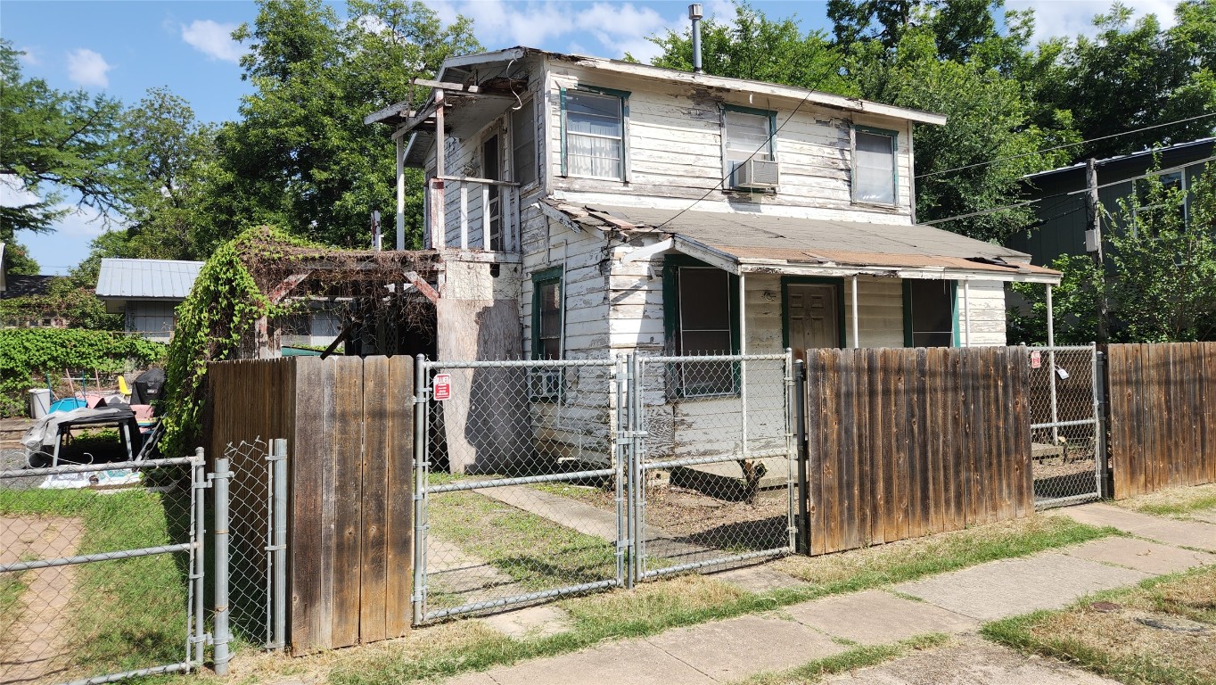 85 Navasota Street Austin, TX 78702 - Photo 3 of 17 View of front of home with a gate, cooling unit, a fenced front yard, and covered porch