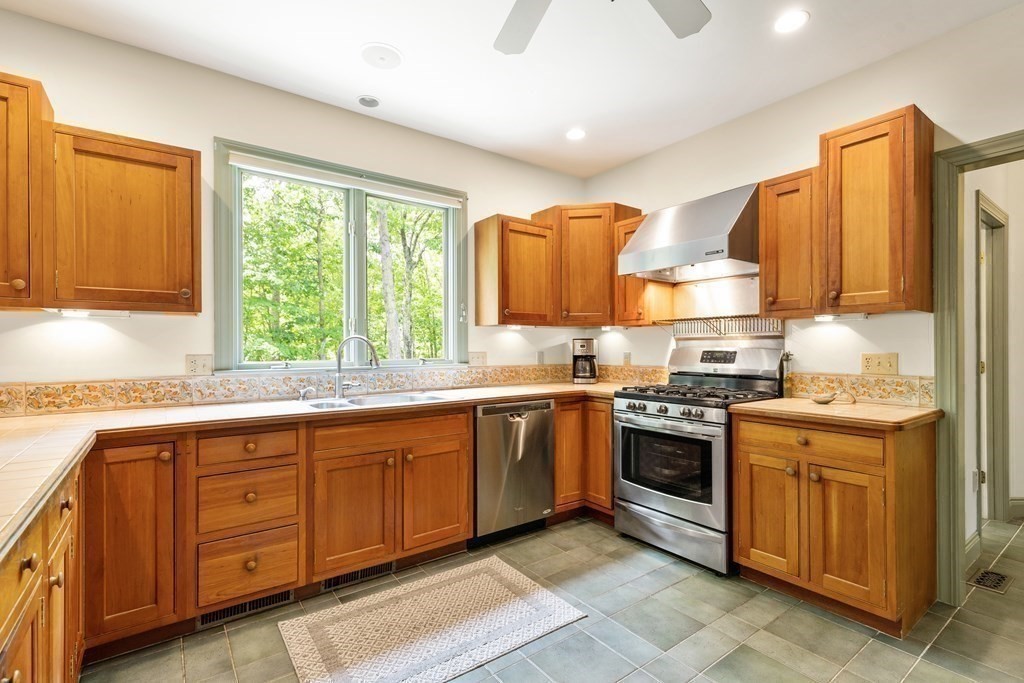 1983 Bay Road Sharon, MA 02067 - Photo 6 of 26 a kitchen with stainless steel appliances granite countertop wooden cabinets a sink and a stove
