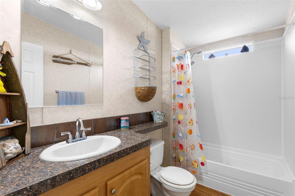 4393 Maple Avenue Edgewater, FL 32141 - Photo 23 of 41 a bathroom with a granite countertop sink toilet and shower