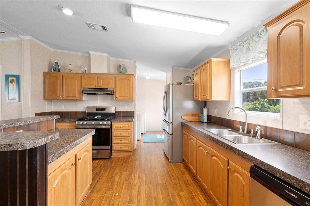4393 Maple Avenue Edgewater, FL 32141 - Photo 7 of 41 a large kitchen with stainless steel appliances granite countertop a sink stove and refrigerator
