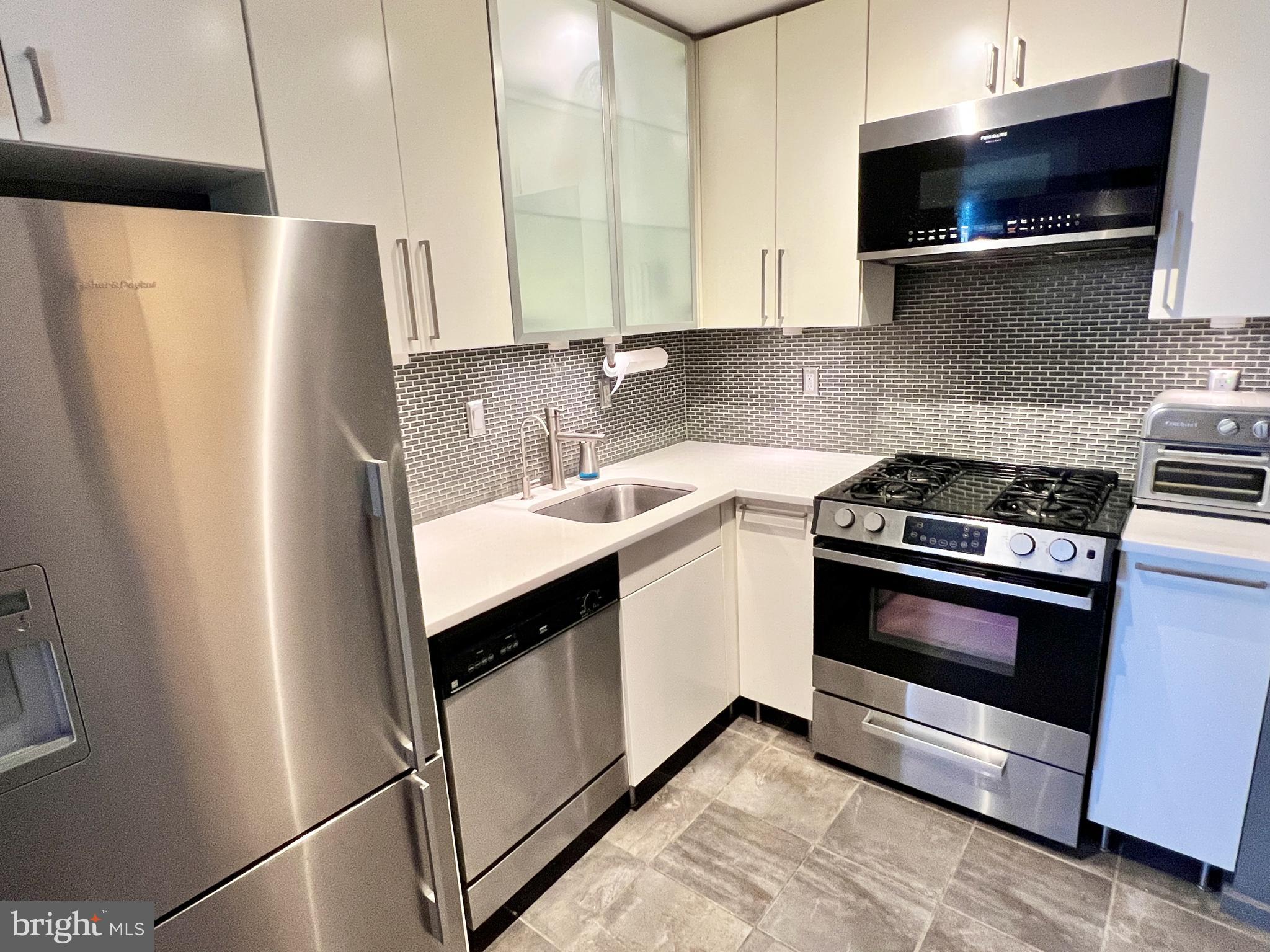 429 N Street Southwest, Unit S510 Washington, DC 20024 - Photo 13 of 45 a kitchen with stainless steel appliances a refrigerator a sink a stove and white cabinets
