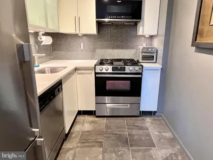 a kitchen with a stove top oven and cabinets