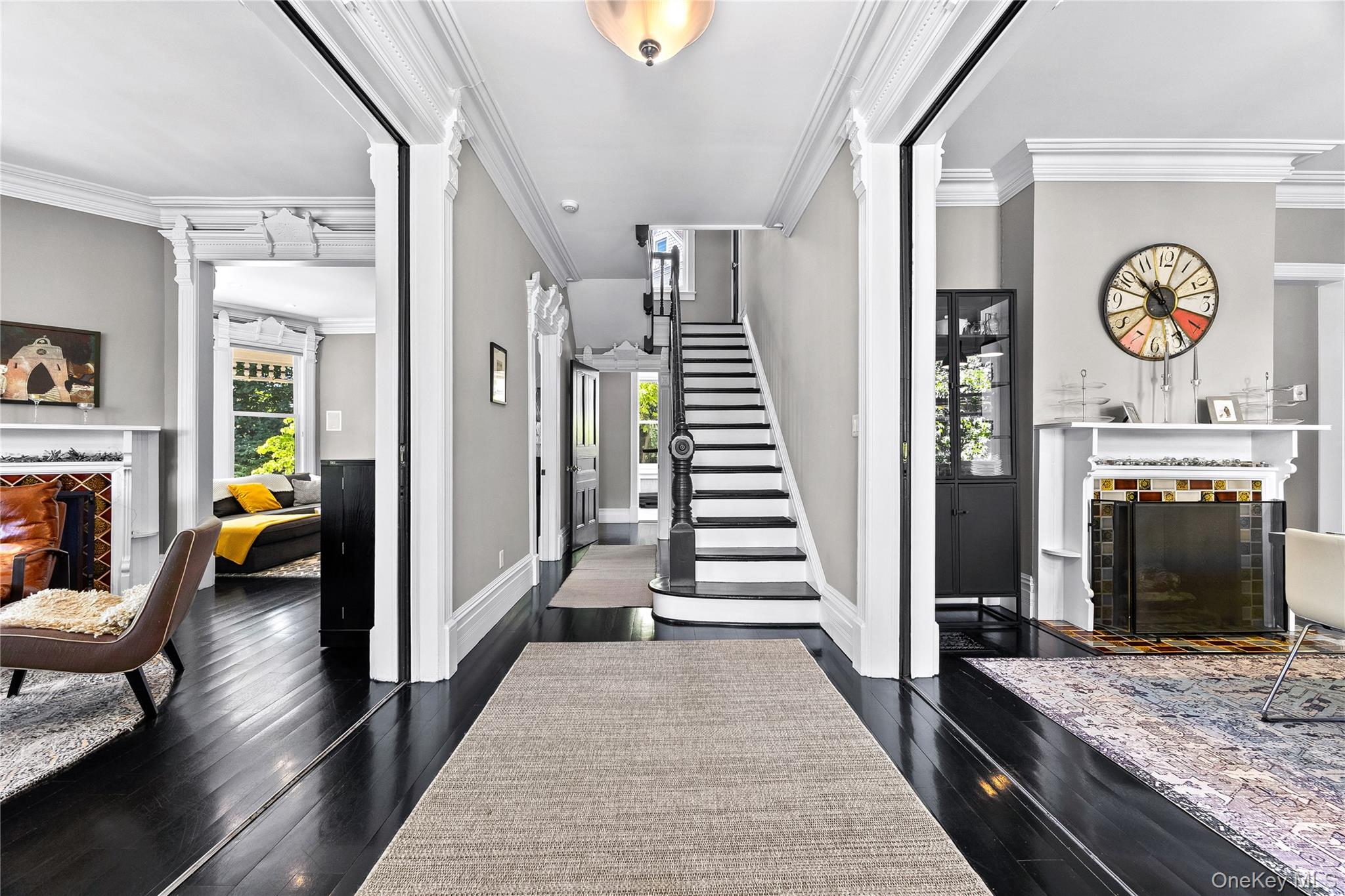 19 Howe Place Bronxville, NY 10708 - Photo 2 of 37 Formal entryway with dark wood-finish flooring, a grand staircase, and detailed crown molding